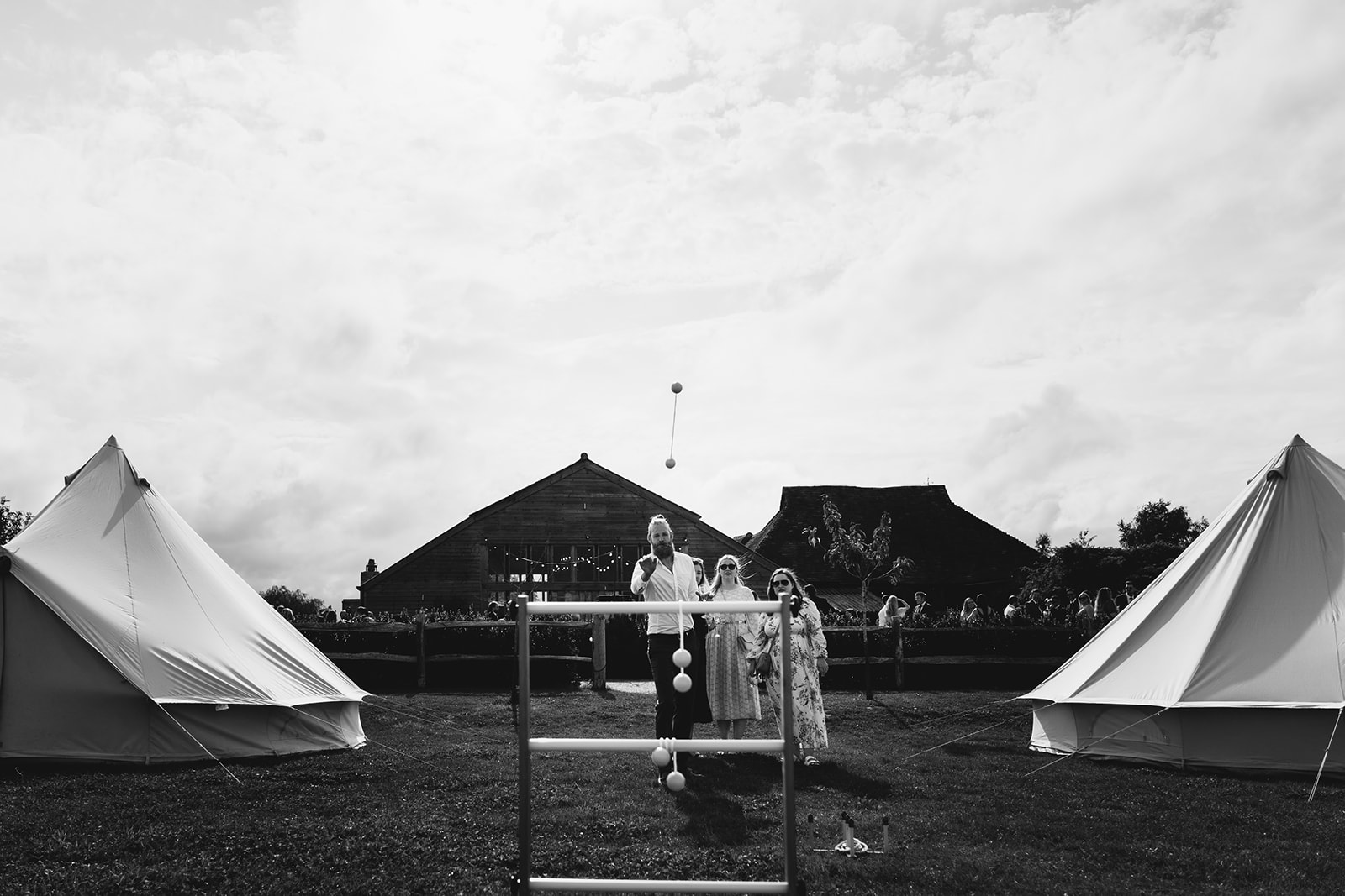 Guests playing lawn games between two bell tents