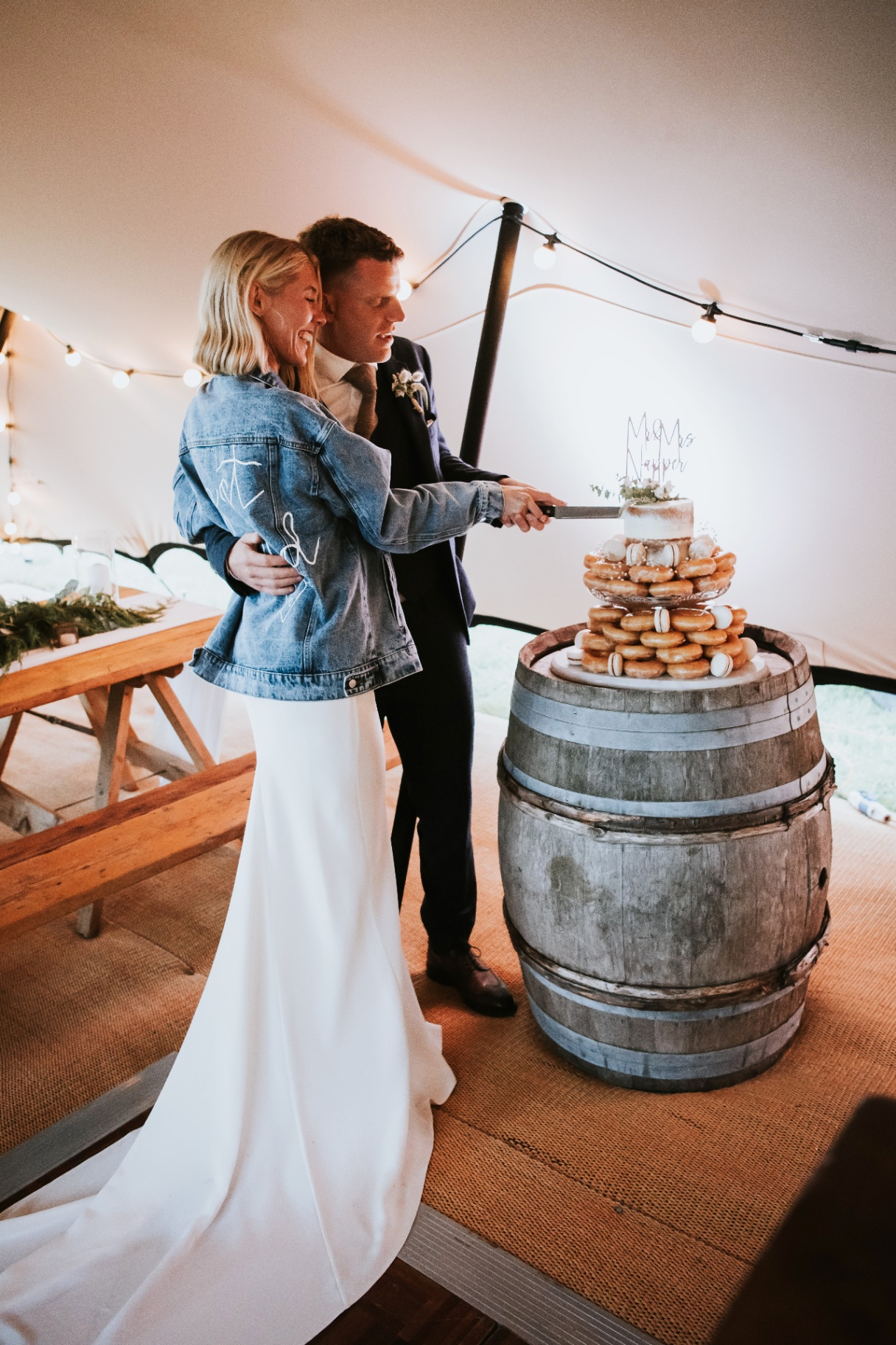 Couple cutting the cake inside the stretch tent
