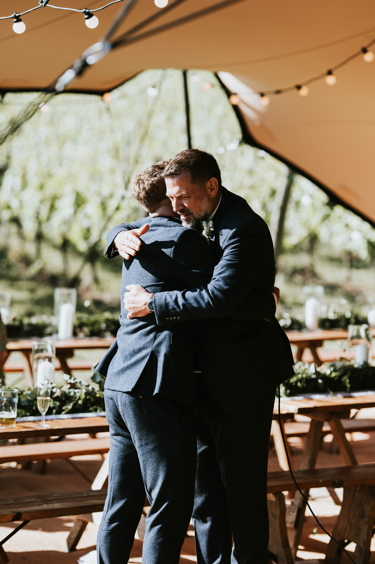 Father and son embracing under the stretch tent canopy