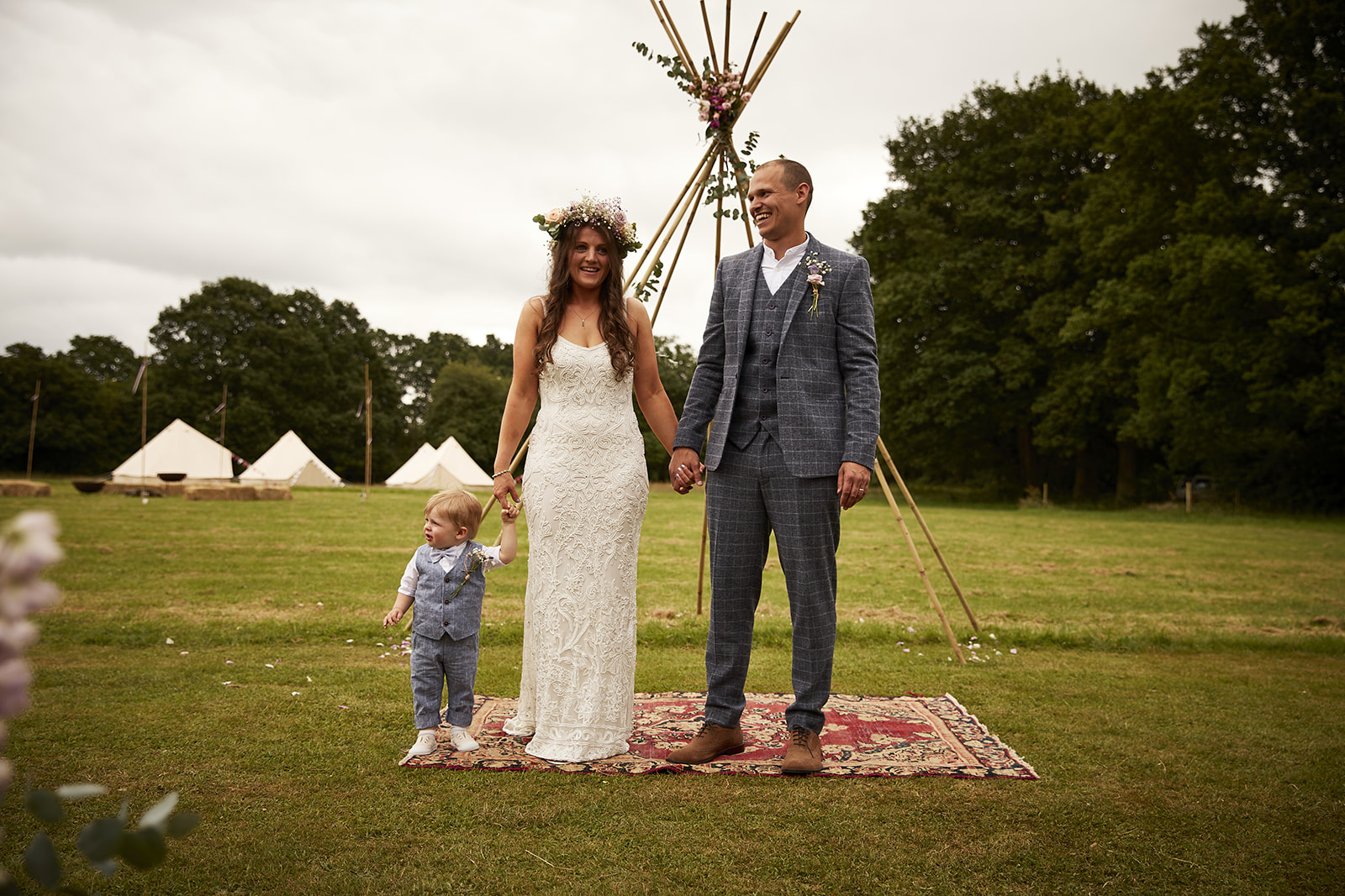 Wedding couple with bell tents behind