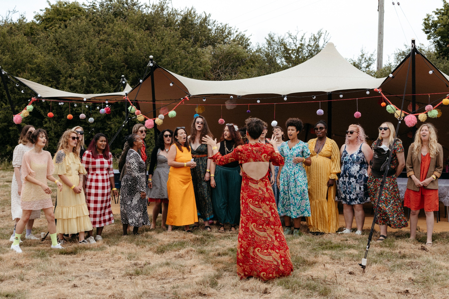 Choir performing in front of a small stretch tent