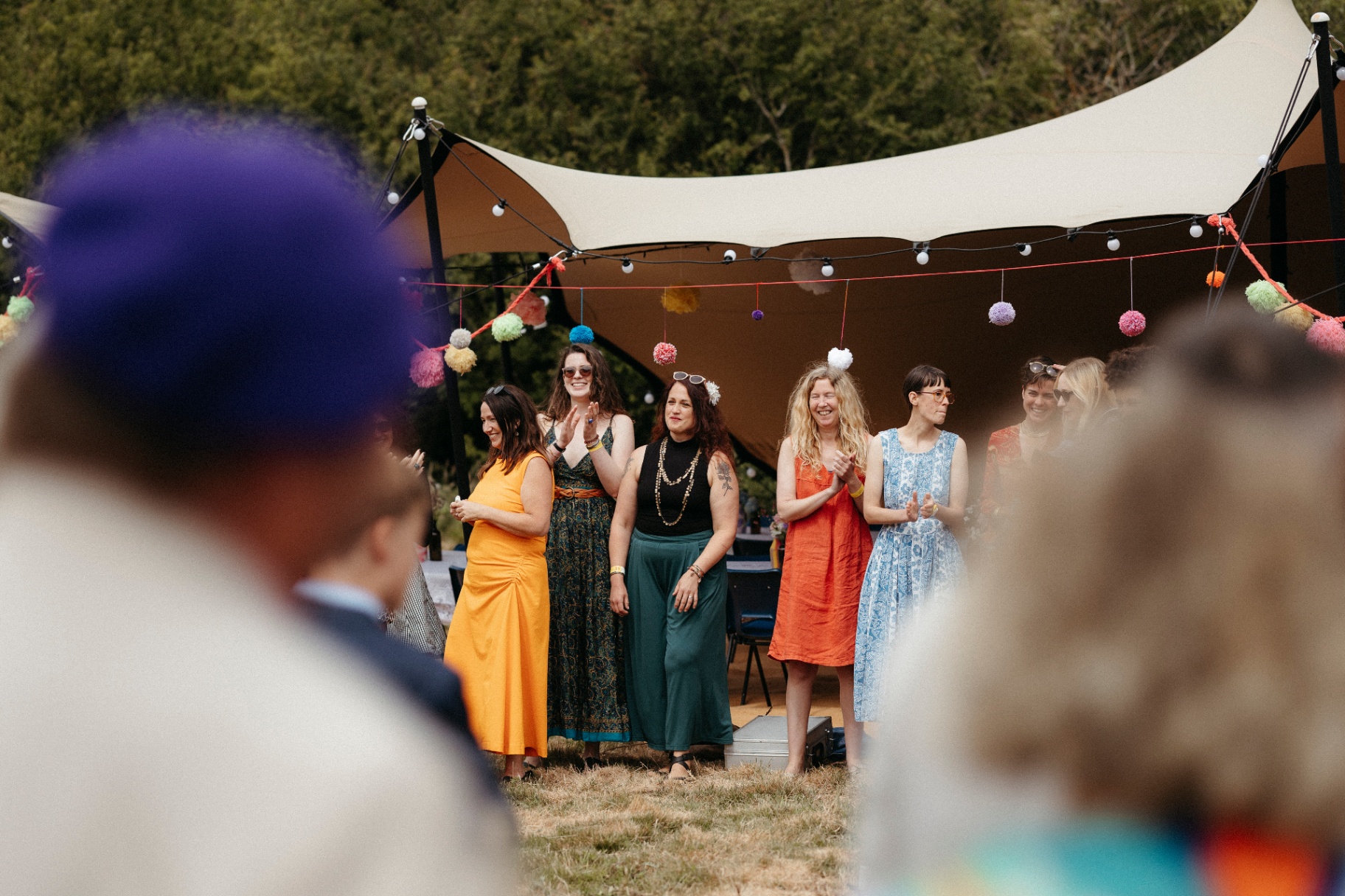 Guests gathered under a small stretch tent