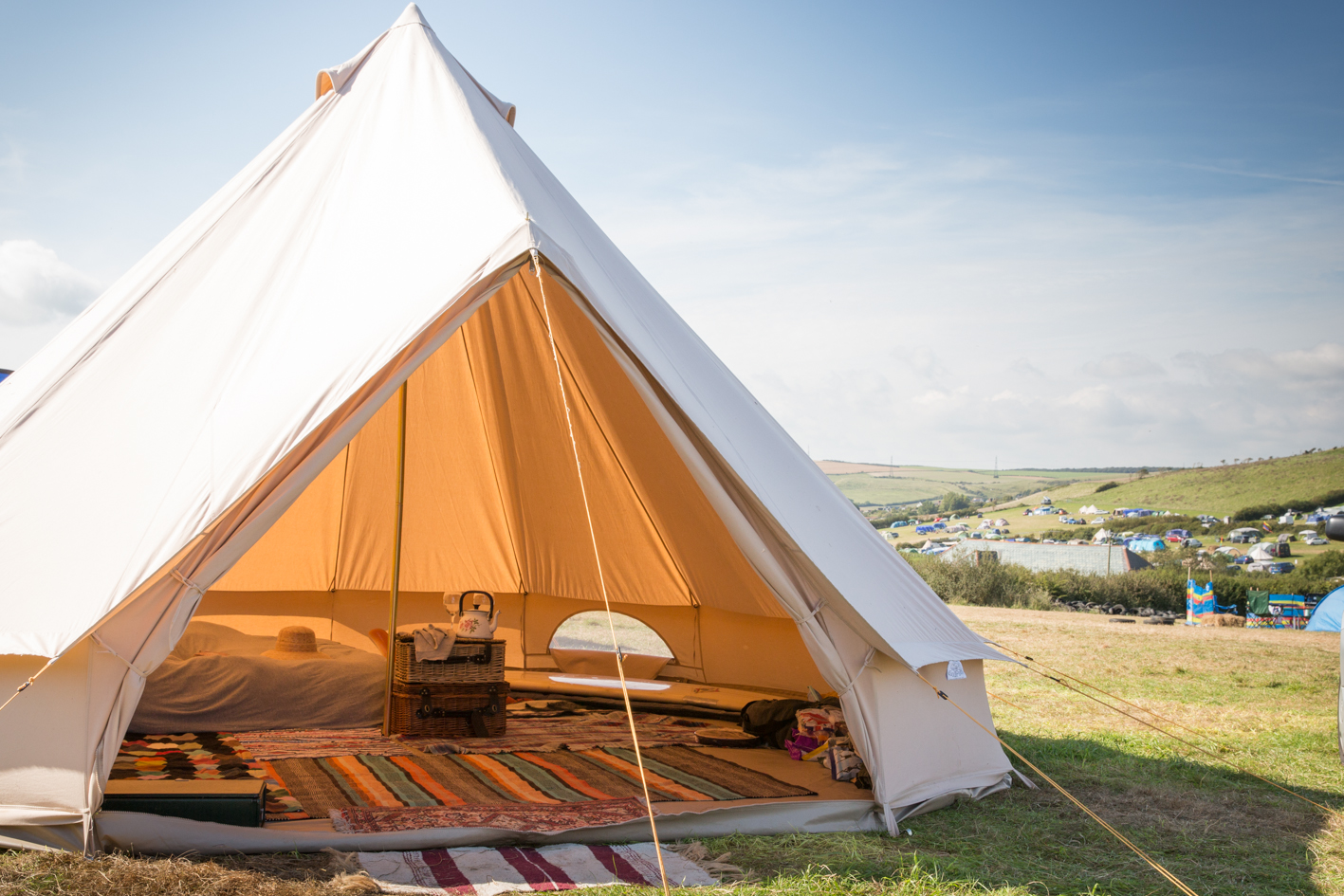 Bell tent with open door overlooking a Guernsey field